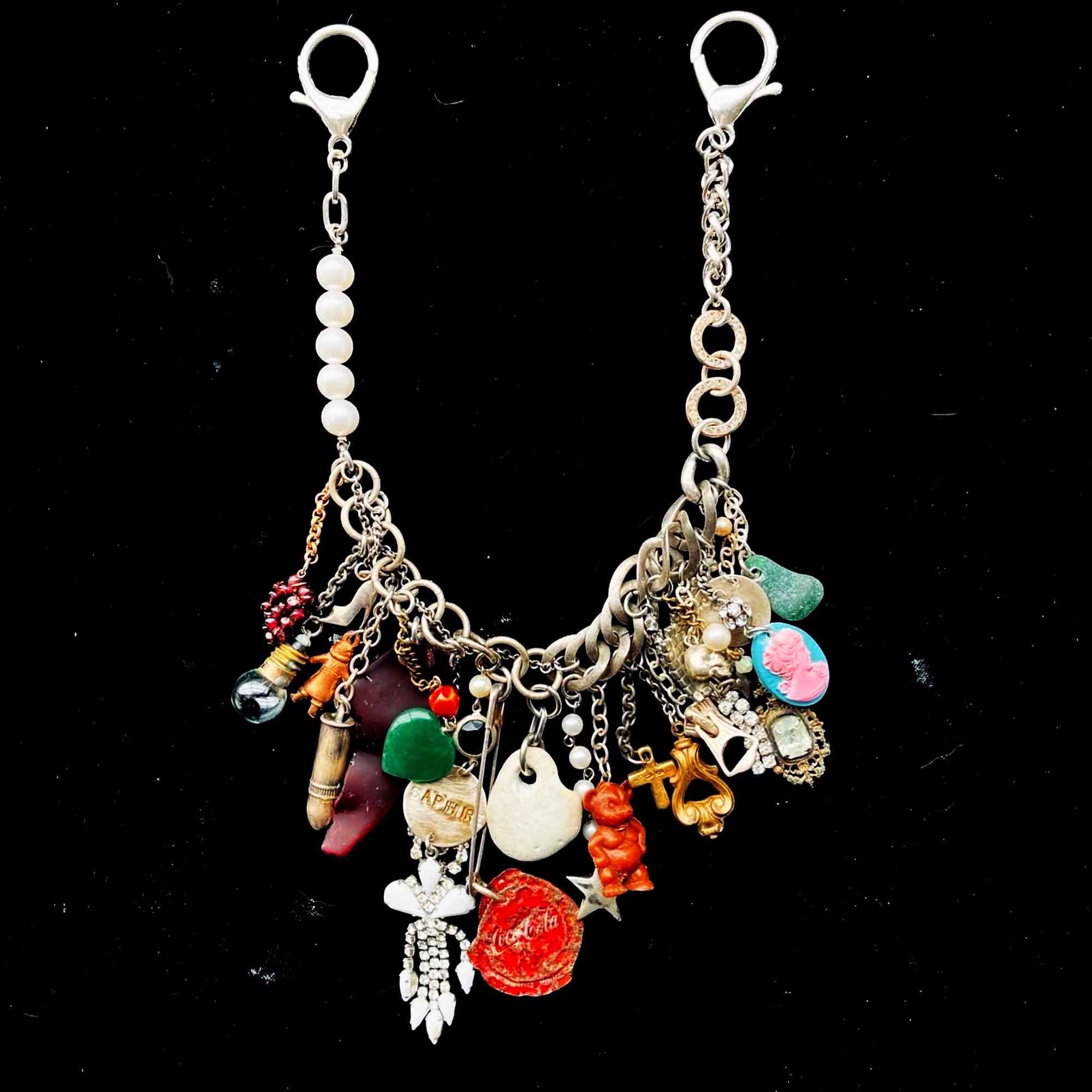 Multicolored charm necklace by Tom Binns on a speckled black background