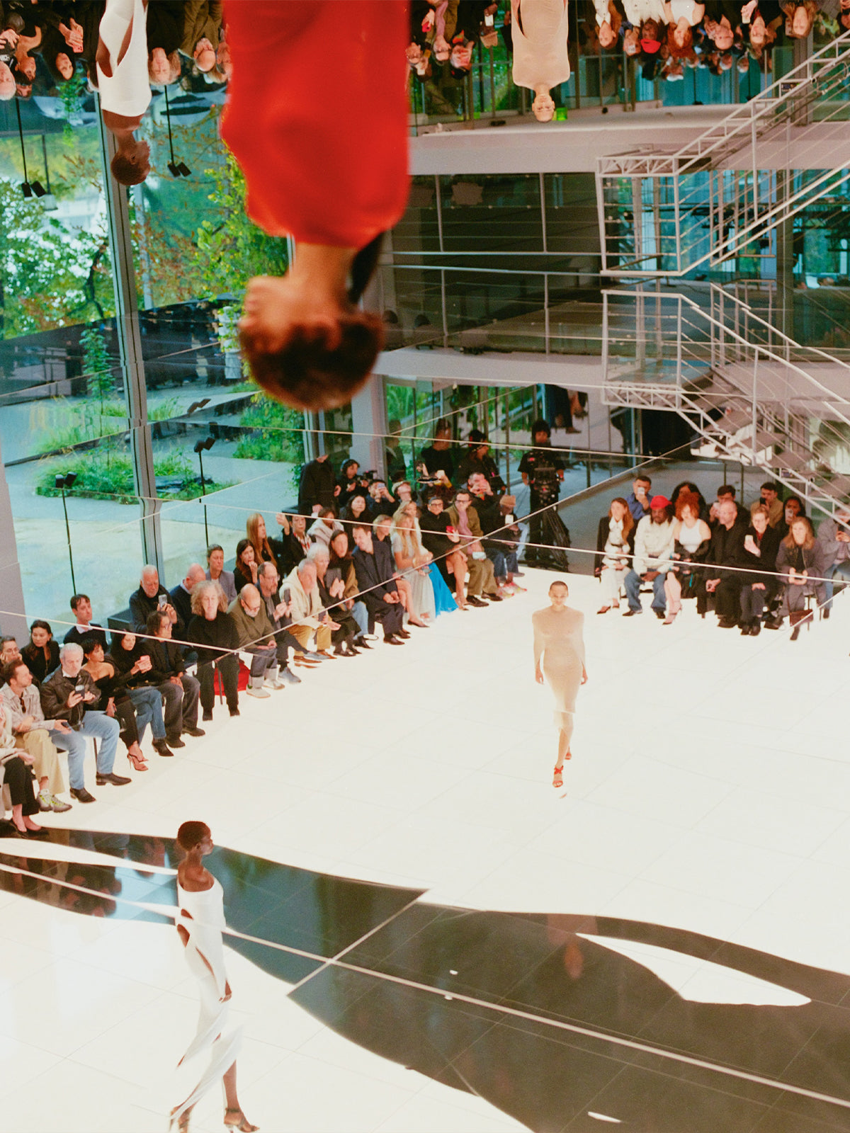 Alaïa fashion show with models walking on a runway and audience watching.