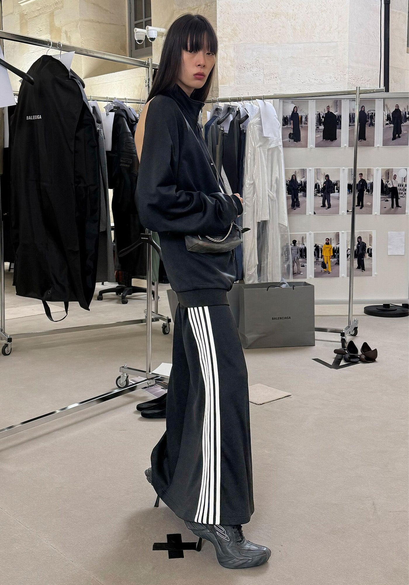 Balenciaga Fall Winter Image wearing a dark outfit with white stripes in Balenciaga Showroom.