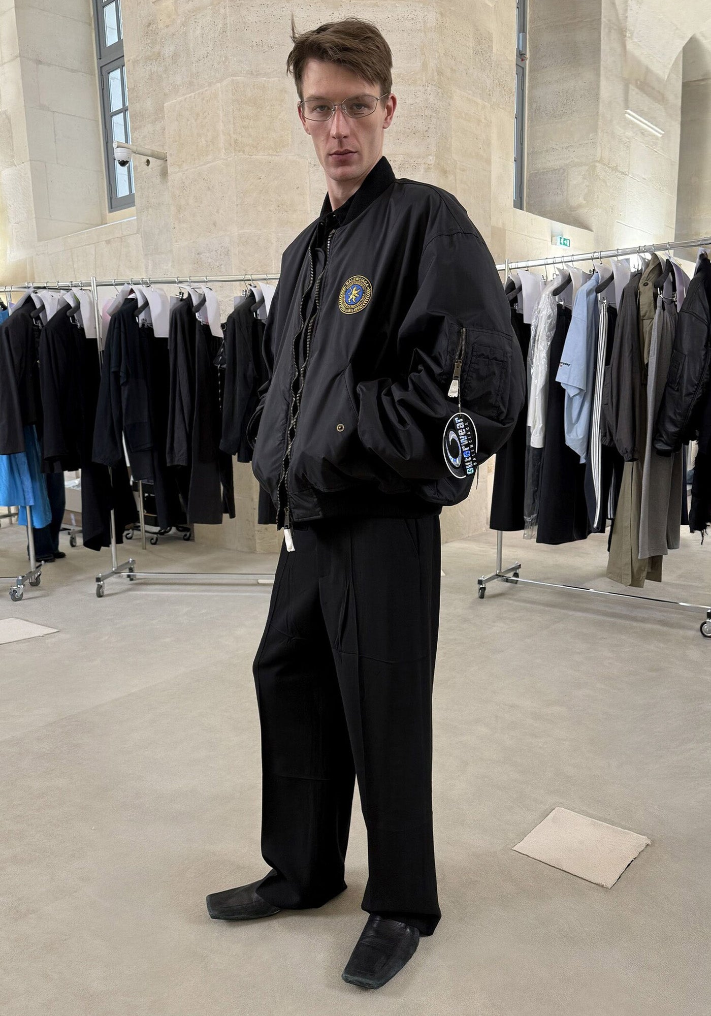 Balenciaga FW25 model wearing a coach jacket in the balenciaga showroom.