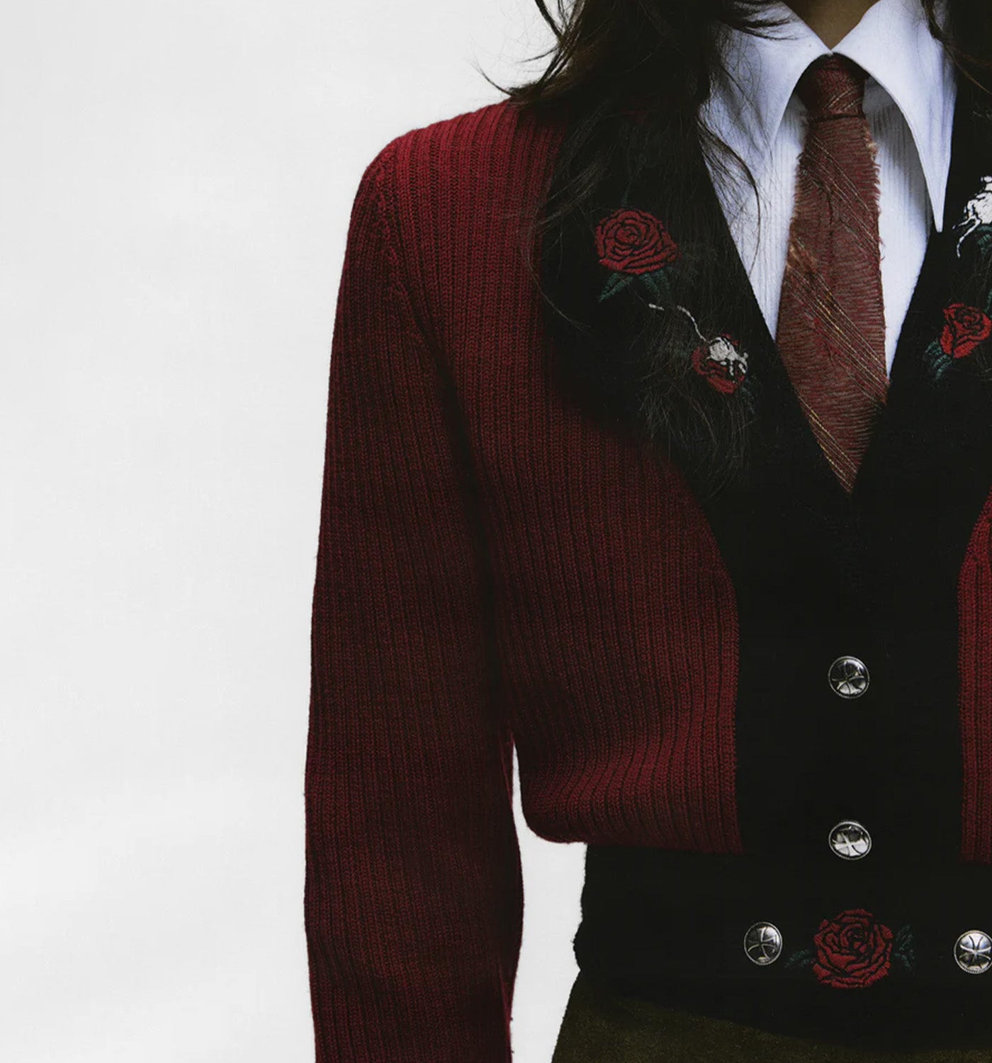 Red ENFANTS RICHES DÉPRIMÉS cardigan over a black suit with floral details on a white background