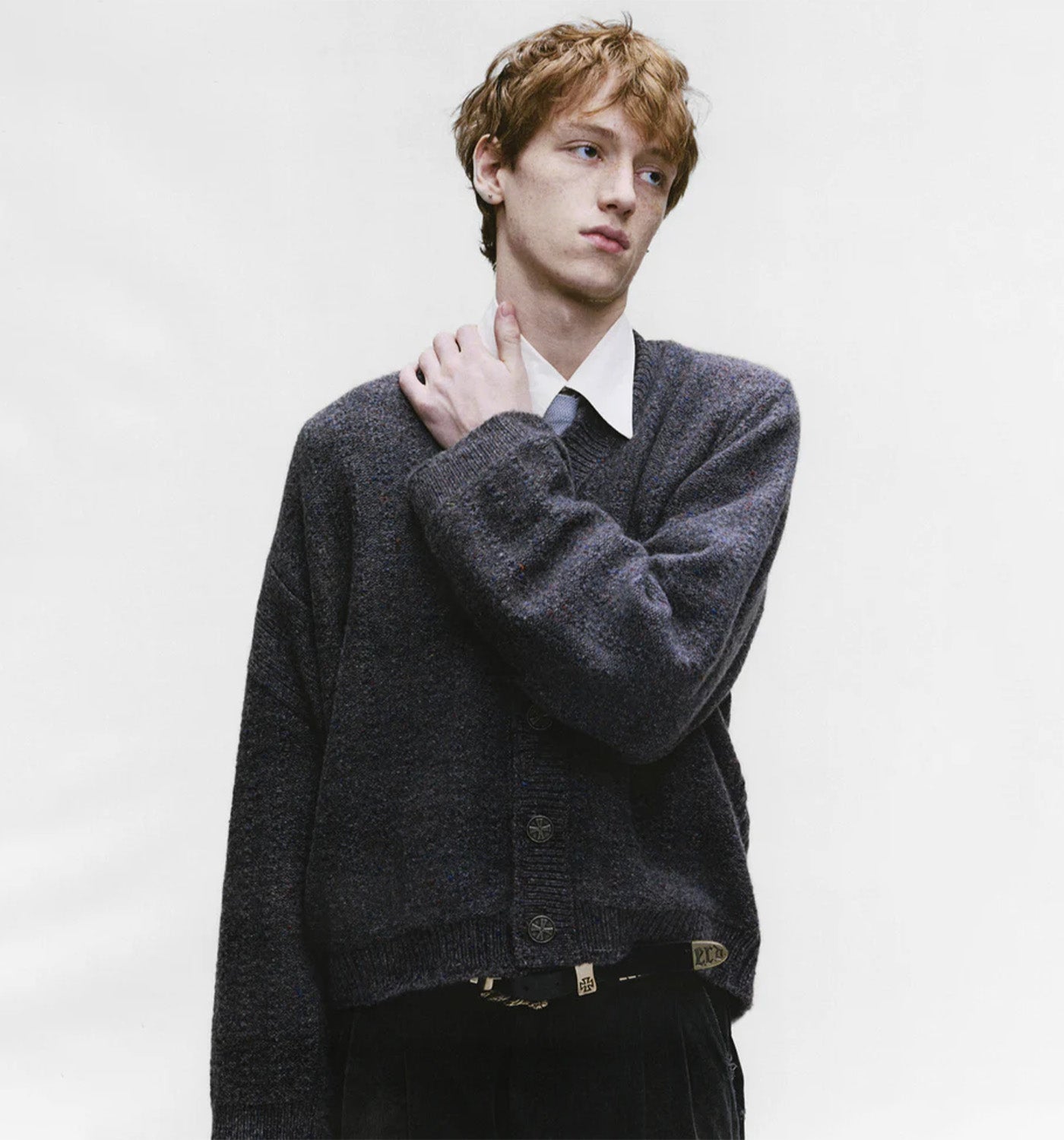 Person wearing a ENFANTS RICHES DÉPRIMÉS dark gray sweater over a white shirt on a plain background