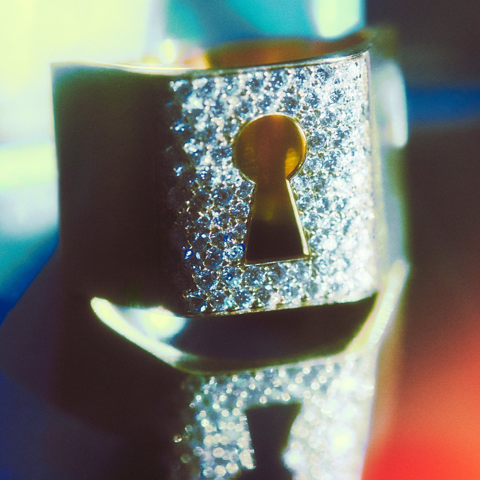 Decorative keyhole Mystery Joy Ring with sparkling gemstones on a blurred background