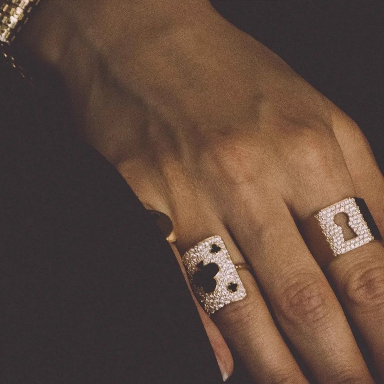 Close-up of a hand wearing two beautiful mystery joy rings on a dark background