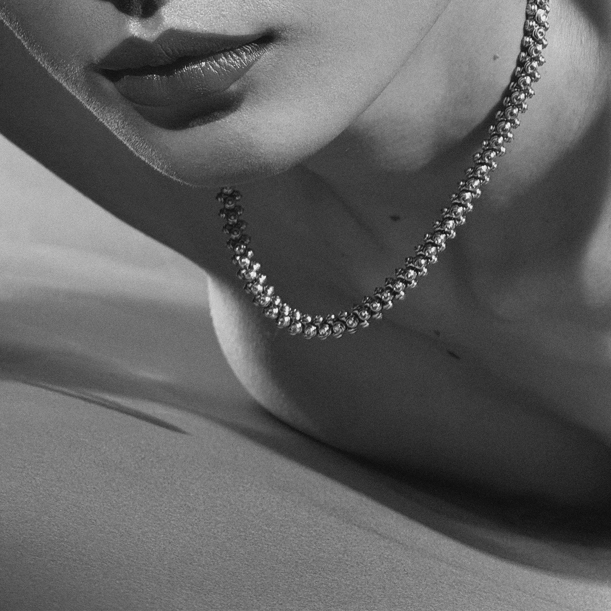 Close-up of a OX jewelry necklace on a person's neck with a neutral background