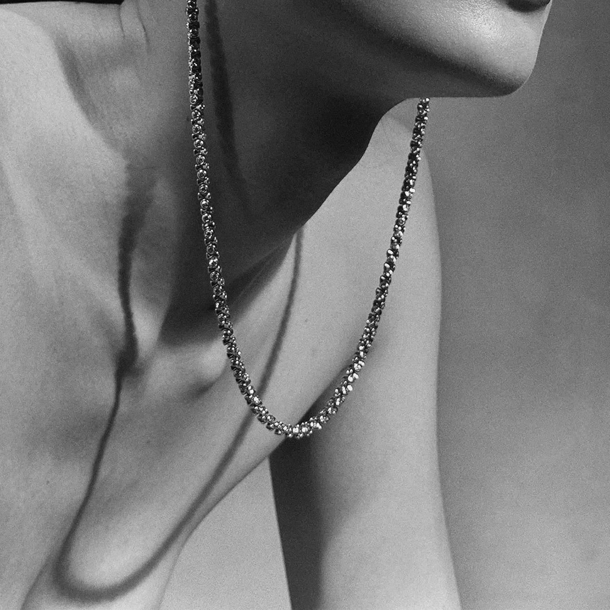 Close-up of a OX jewelry necklace on a person's neck with a neutral background