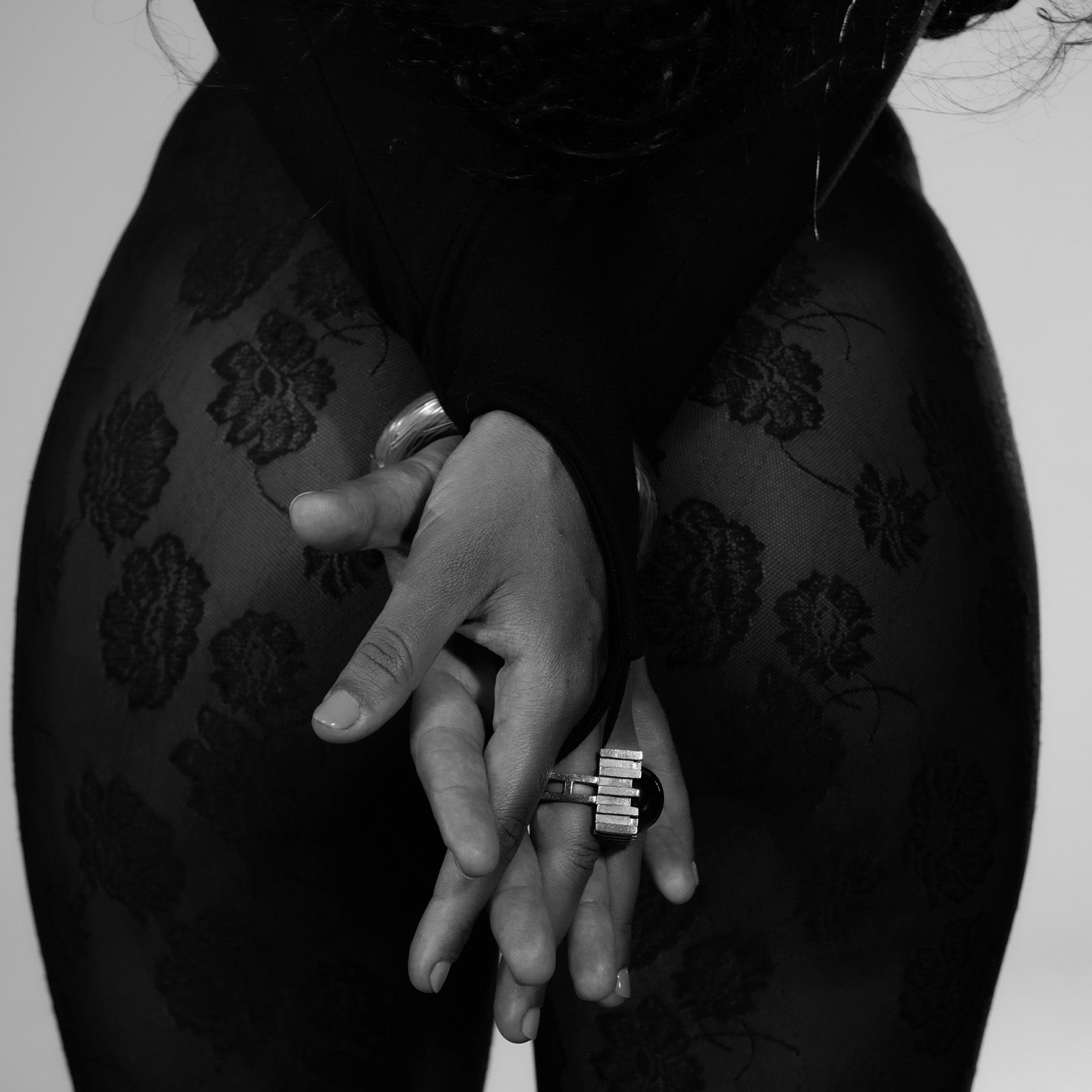 Black and white close-up of hands with rings.