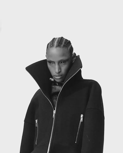 Person with black Rick Owens jacket on modeling for camera, 